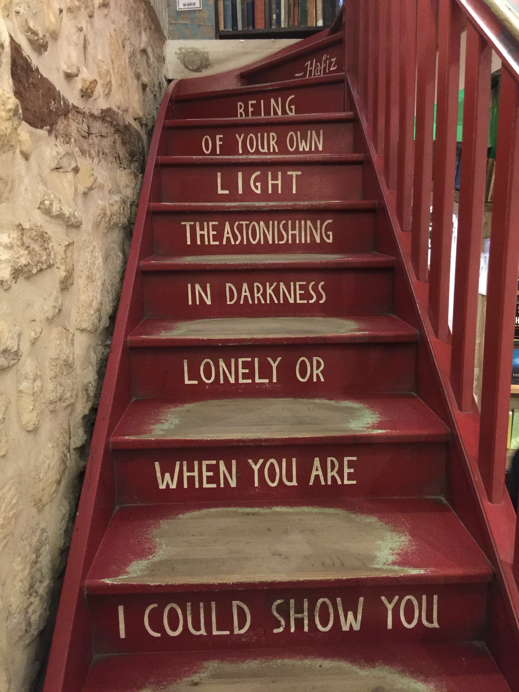 Red staircase with Hafiz poetry on each step: I could show you when you are lonely or in darkness the astonishing light of your own being